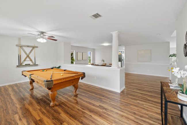 Rec room featuring wood finished floors, ornate columns, pool table, and ceiling fan | Image 5