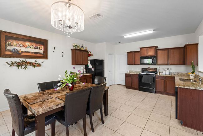 Dining room featuring visible vents, a notable chandelier, and light tile patterned floors | Image 13