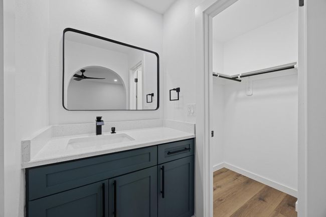 Bathroom featuring vanity, wood finished floors, and a walk in closet | Image 19
