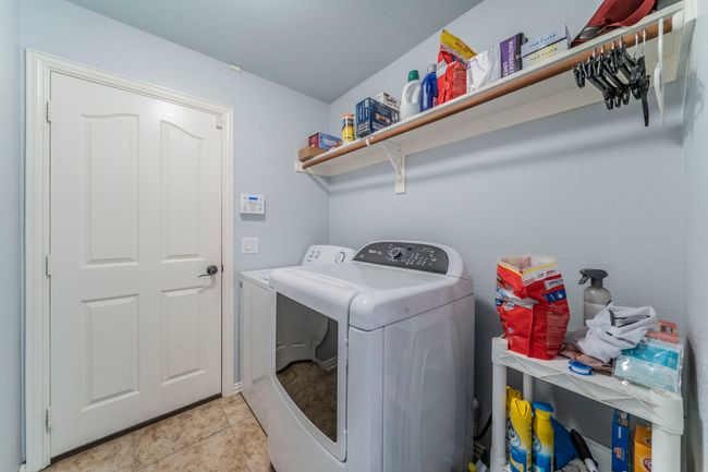 Laundry area featuring washer and dryer and light tile patterned floors | Image 29