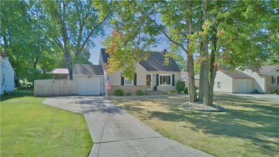 View of front facade with a front yard and a garage | Image 1