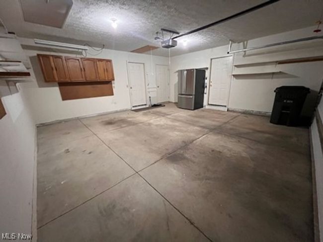 Garage featuring freestanding refrigerator and a garage door opener | Image 29