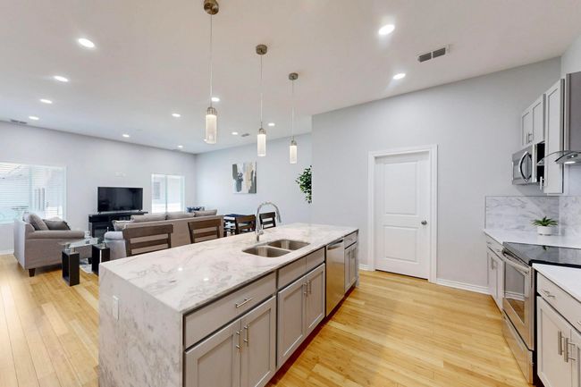 Kitchen featuring stainless steel appliances, a sink, light wood-style floors, gray cabinets, and recessed lighting | Image 5