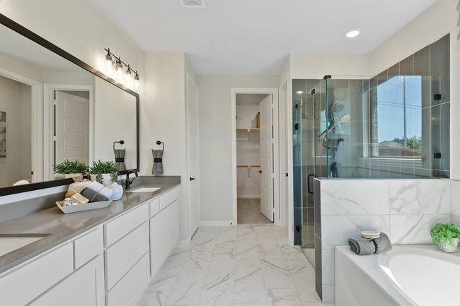 Bathroom with a shower stall, double vanity, a garden tub, a spacious closet, and marble look tile flooring | Image 4