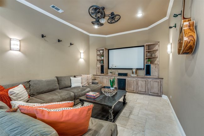 Cinema room featuring baseboards, stone tile floors, ornamental molding, and recessed lighting | Image 13