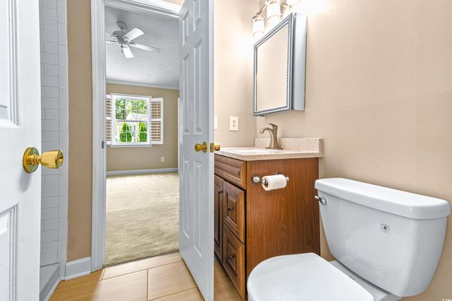 Bathroom with a ceiling fan, a textured ceiling, vanity, baseboards, and toilet | Image 27