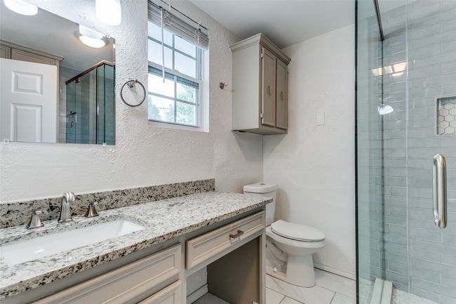 Full bathroom featuring a shower stall, toilet, and vanity | Image 17