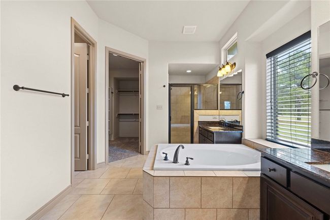 Bathroom with a stall shower, two vanities, a walk in closet, and tile patterned flooring | Image 13