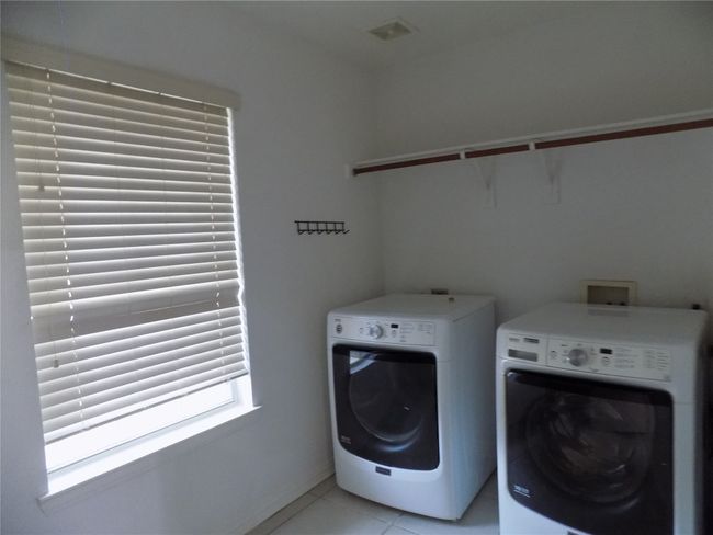 Washroom with washer and dryer and light tile patterned floors | Image 18