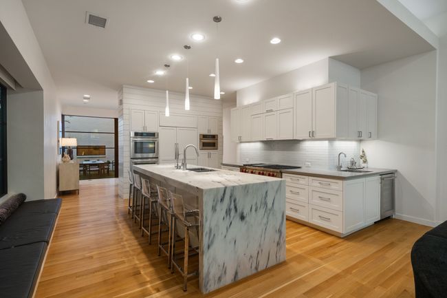 Kitchen featuring a sink, appliances with stainless steel finishes, light wood-style flooring, a kitchen bar, and recessed lighting | Image 4