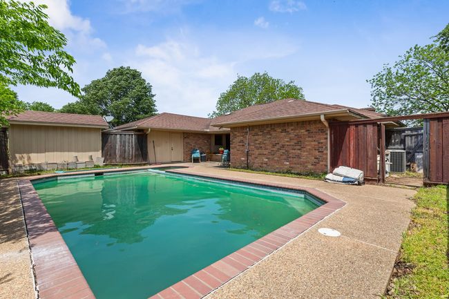 View of swimming pool with central AC, fence, and a fenced in pool | Image 35