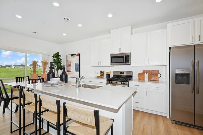 (Photo of model home, features will vary) A subway tile backsplash atop the 5-burner gas cooktop with an overhead microwave meets style with functionality | Image 4
