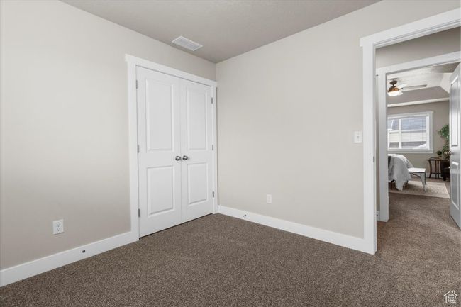 Unfurnished bedroom featuring carpet floors, baseboards, and a closet | Image 30