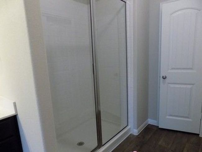 Bathroom featuring a stall shower, vanity, wood finished floors, and baseboards | Image 15