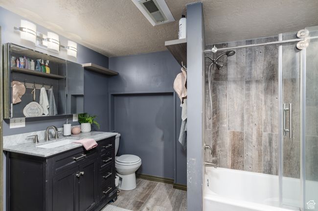 Bathroom with wood finished floors, vanity, bathtub / shower combination, and a textured ceiling | Image 19