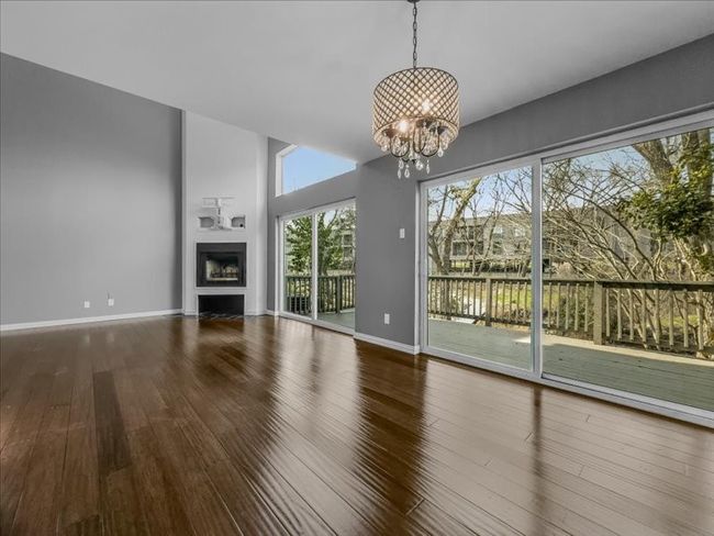 Living room featuring a notable chandelier and wood-type flooring | Image 4