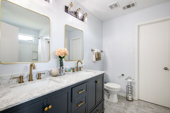 Bathroom featuring double vanity, a shower with shower curtain, and tile patterned flooring | Image 15