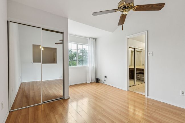 Primary bedroom with mirrored closet in both the bedroom and the ensuite. Large window and tall ceilings. | Image 21