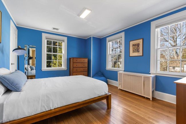 Bedroom with baseboards, crown molding, and wood finished floors | Image 19