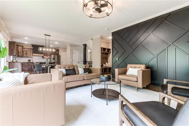 Living room with a chandelier, crown molding, and a decorative wall | Image 18
