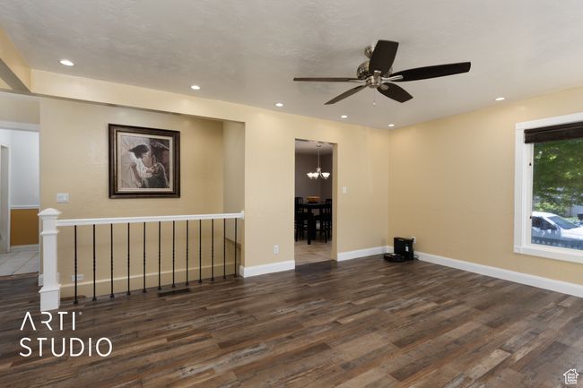 Unfurnished room featuring wood finished floors, a ceiling fan, baseboards, recessed lighting, and a chandelier | Image 37