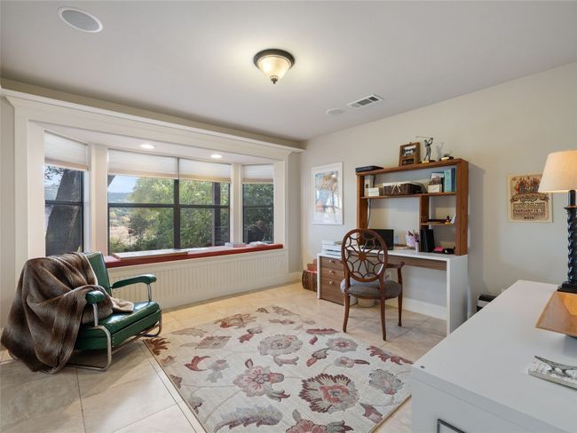 Study has bay window overlooking the back patio and yard. | Image 32