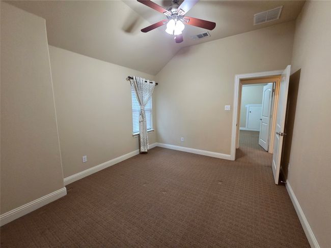 Spare room with ceiling fan, dark colored carpet, and lofted ceiling | Image 28