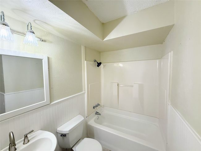 Bathroom with a wainscoted wall and shower / bath combination | Image 21