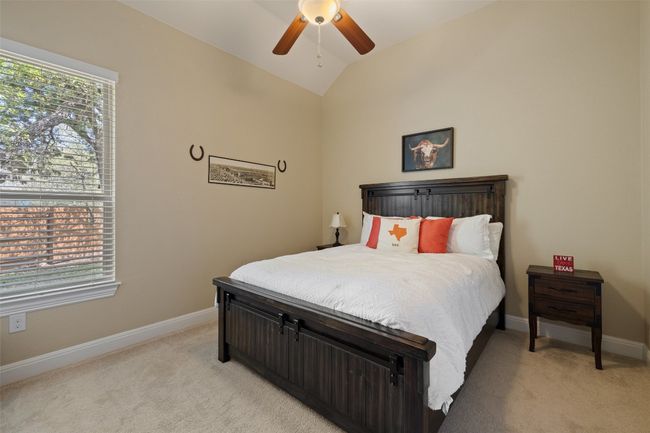 Spacious secondary bedroom situated away from primary bedroom with a vaulted ceiling, walk in closet & light carpet | Image 31