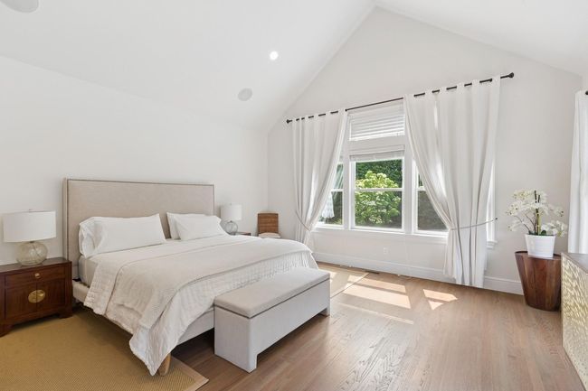 Bedroom with light wood-type flooring, baseboards, and high vaulted ceiling | Image 11