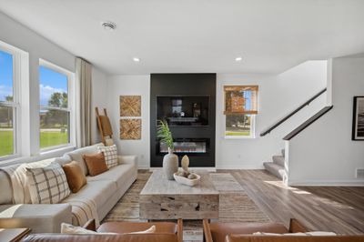 (Photo of decorated model, actual homes color and finishes will vary)This spacious family gathering area seamlessly connects to the kitchen and dining areas, perfect for entertaining. It also features many large windows providing warm natural light | Image 1