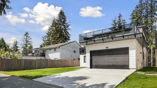 Modern home with concrete driveway and a balcony | Image 26