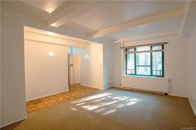 Empty room with light carpet and beamed ceiling | Image 2