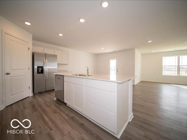 kitchen featuring a sink, a center island with sink, white cabinetry, and stainless steel appliances | Image 23