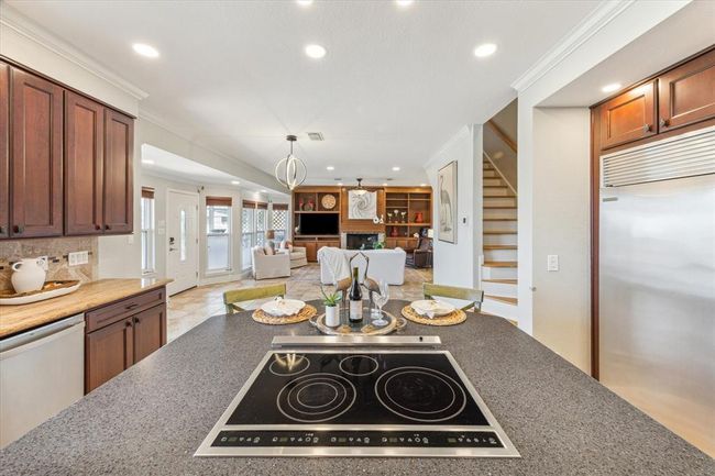 Experience modern cooking with the island stove featuring a sleek, retractable vent hood. | Image 19