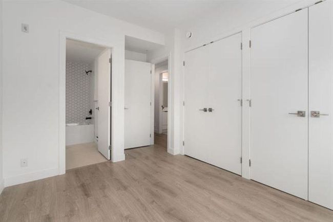 Unfurnished bedroom featuring ensuite bathroom, light wood-type flooring, and two closets | Image 13