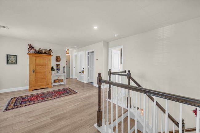 Loft space currently being used as a Living area featuring wood finished floors, recessed lighting, baseboards, and ceiling fan | Image 12