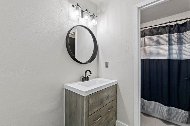 Full bathroom featuring vanity, a shower with shower curtain, and a textured wall | Image 21