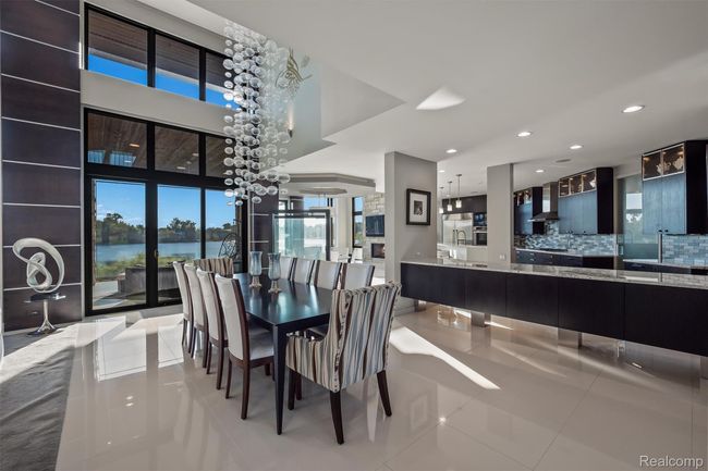 Dining room featuring a water view, light tile patterned floors, a chandelier, and recessed lighting | Image 9