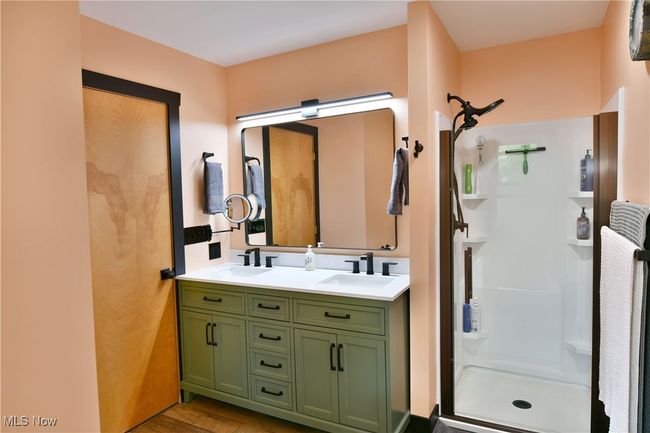 Full bathroom featuring a stall shower, double vanity, and wood finished floors | Image 32