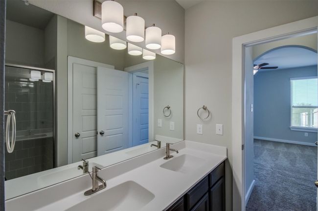 Bathroom featuring a stall shower, double vanity, baseboards, and ceiling fan | Image 14