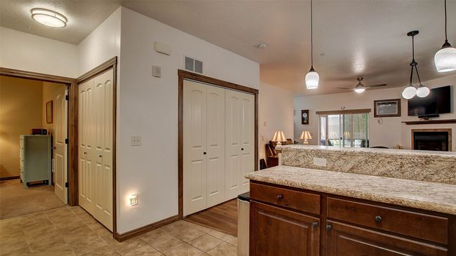 Additional storage and pantry shelving in the hallway adjacent to the kitchen providing lots of storage and access to the water heater. | Image 13