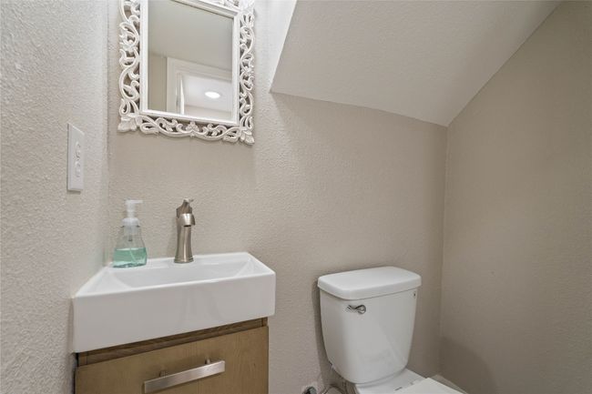 Chic downstairs powder room with designer mirror, brushed nickel faucet, and space-saving vanity — perfect for guests. | Image 7