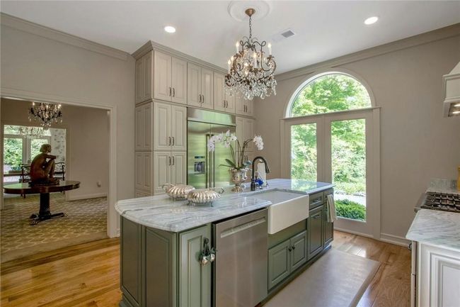 Kitchen with stainless steel appliances, sink, an island with sink, and light hardwood / wood-style flooring | Image 16