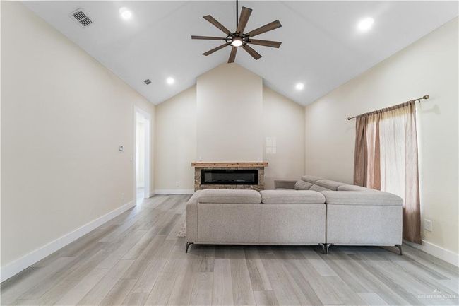 Living room featuring high vaulted ceiling, ceiling fan, and light hardwood / wood-style floors | Image 13