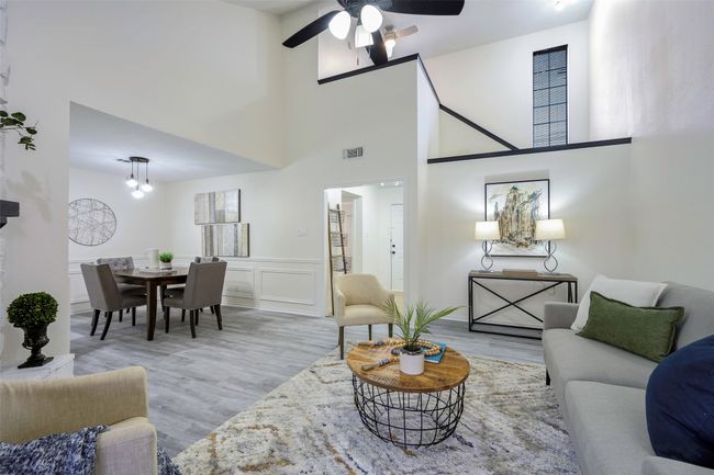 Living room featuring visible vents, wood finished floors, a ceiling fan, and a decorative wall | Image 10