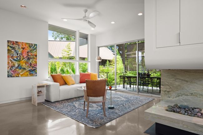 Formal living room with views of the city, the treetop dining, vapor fireplace and hidden bigscreen tv. | Image 16