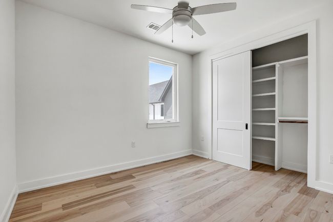 Unfurnished bedroom with light wood-style flooring, baseboards, a closet, and a ceiling fan | Image 23