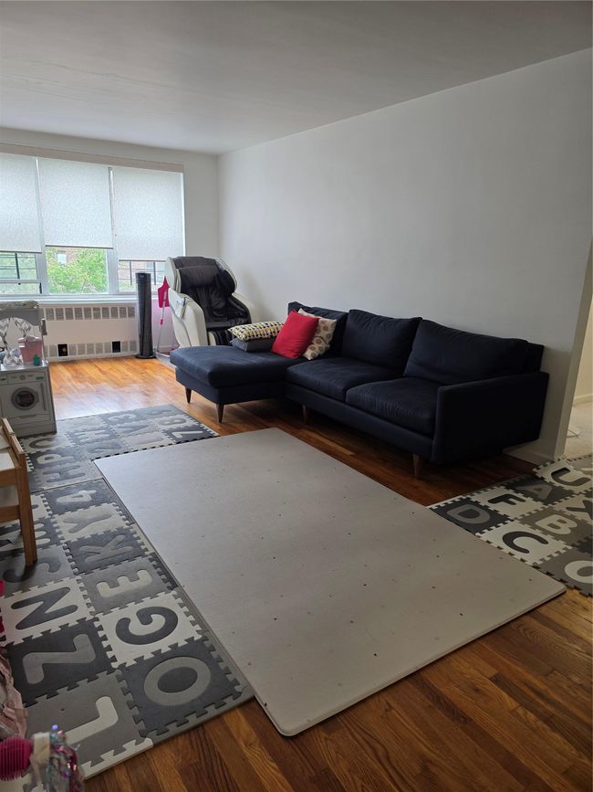 Living room featuring radiator heating unit and wood finished floors | Image 6