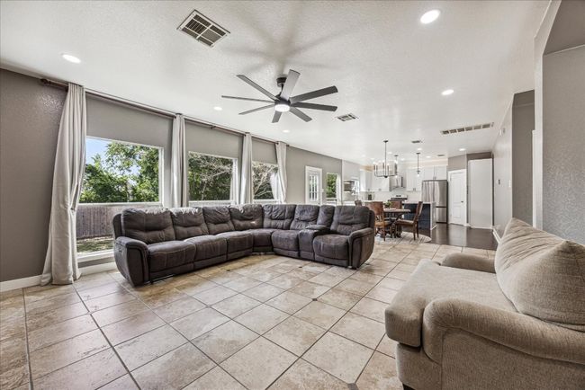 Living room featuring recessed lighting, visible vents, and ceiling fan with notable chandelier | Image 9
